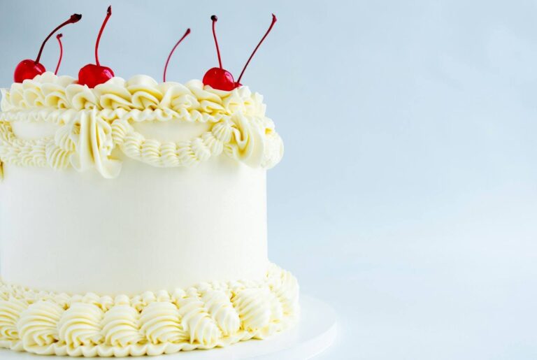 A cake topped with icing and garnished with a cherry.