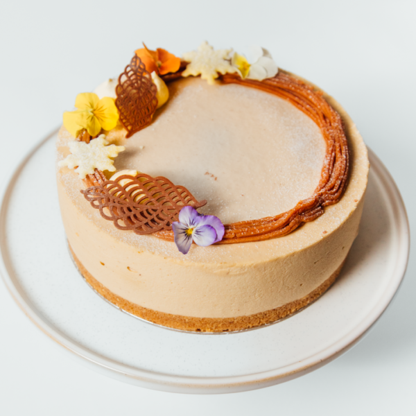 Chestnut Tiramisu 2 Creamy cake with floral and chocolate decorations on a white plate.