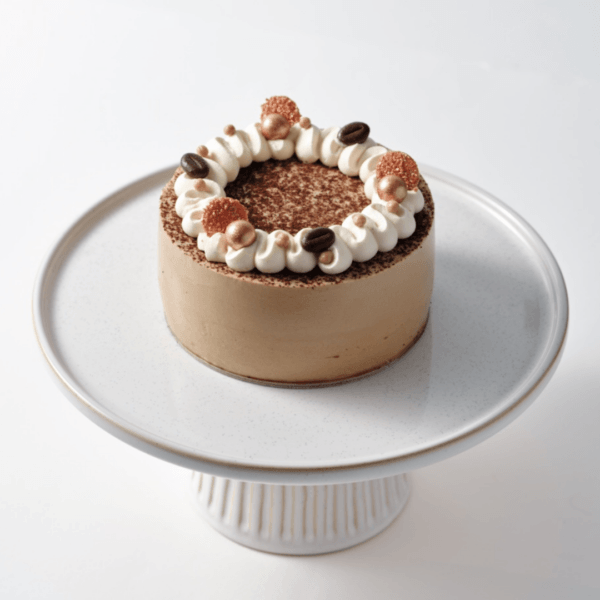 Coffee 2 Tiramisu cake on a white pedestal stand.
